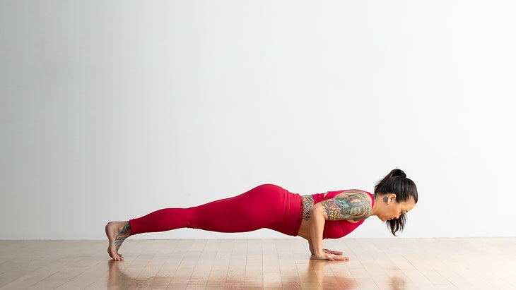 Woman performing Four Limbed Staff Pose