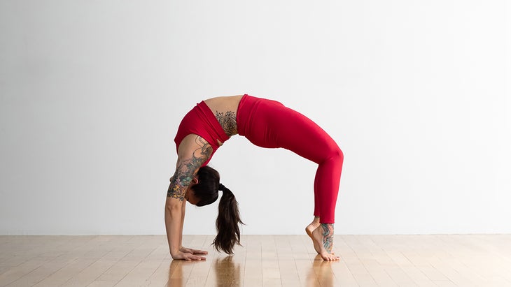 Person demonstrating Wheel Pose variation on the toes