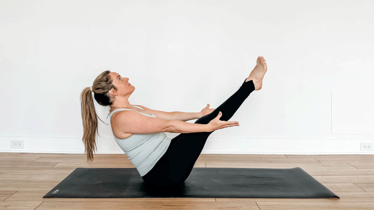 Yoga teacher practicing core strength in Boat Pose