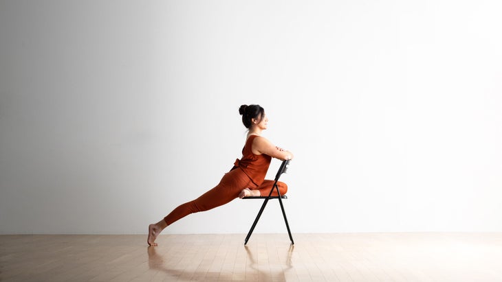Noemi Nunez practices Pigeon Pose in a chair.