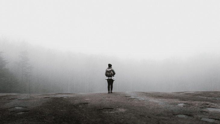 A woman hiking in the fog as one of many ways to be mindful