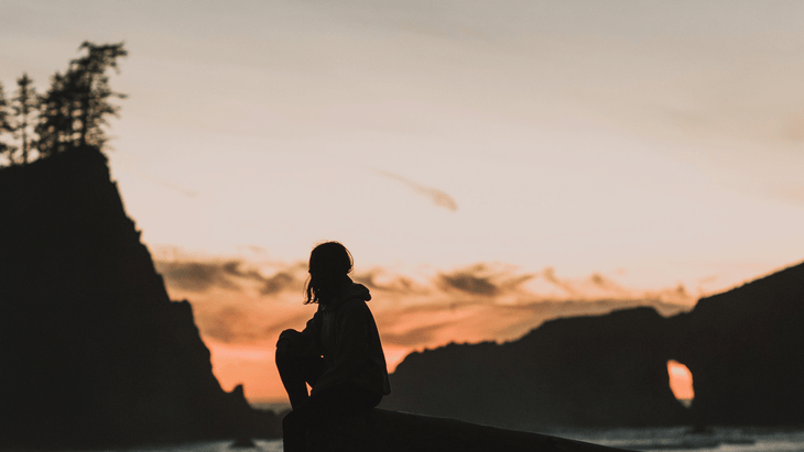 Woman sitting down outside after stretches to slow down during the new Moon